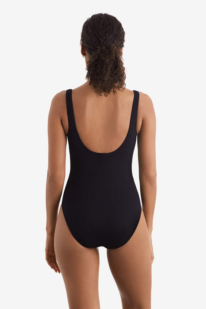 Woman faced away wearing a black one-piece swimsuit