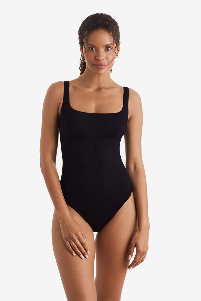 Woman wearing a black one-piece swimsuit