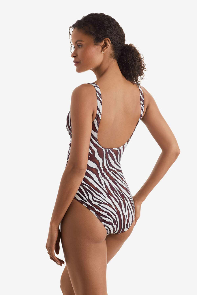 Woman turned left wearing a one-piece zebra print swimsuit